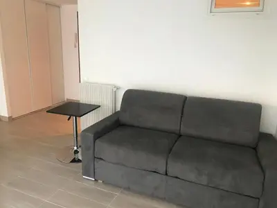 a couch in a living room with a table at Studio Libération Piscine centre ville Nice in Nice