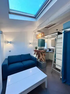 a living room with a blue couch and a kitchen at Midnight Blue - Heart of Nice - Breakfast - AC -Wi-Fi in Nice