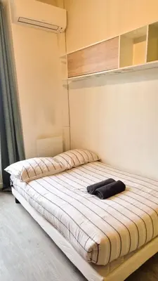 a bed with a black shirt on top of it at Joli T3 moderne avec terrasse & climatisation in Nice