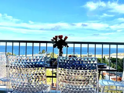 a table with chairs and a vase of flowers on a balcony at Vue Mer Panoramique - Terrasse - Climatisation - 2 Bedrooms - Wifi - Cuisine - Tramway in Nice