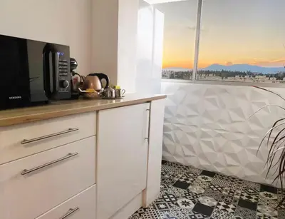 a living room with a microwave and a large window at Vue Mer Panoramique - Terrasse - Climatisation - 2 Bedrooms - Wifi - Cuisine - Tramway in Nice