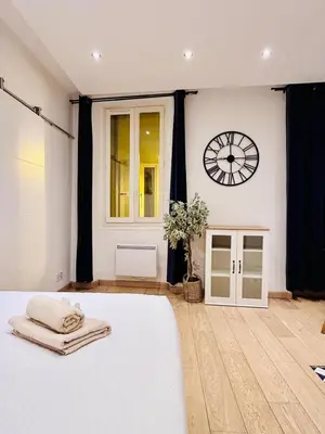 a bedroom with a bed and a clock on the wall at Old Town Immersion-Breakfast-Central-Self Check-in in Nice