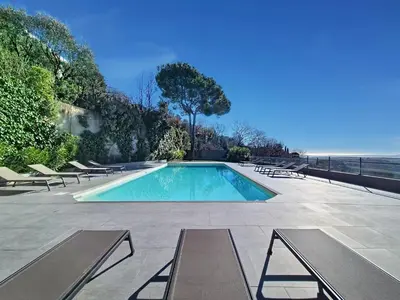 a swimming pool with lounge chairs and the ocean at Domaine Datcha - La Dolce Vita, en toute intimité in Aspremont