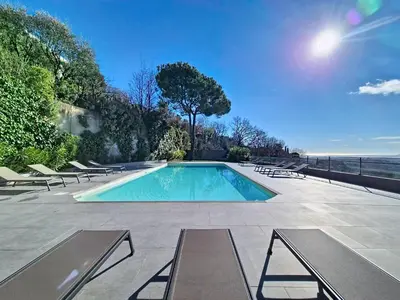 a swimming pool with lounge chairs next to the ocean at Domaine Datcha - La Dolce Vita, en toute intimité in Aspremont