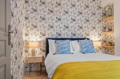 a bedroom with a bed with a floral wallpaper at Baie des Anges in Nice
