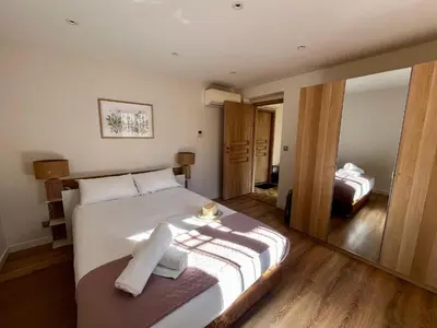 a bedroom with a large white bed and a mirror at Appartement Jasmin 2 pièces central à Cagnes-sur-Mer in Cagnes-sur-Mer