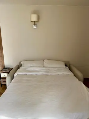 a large white bed in a room with a lamp at Appartement Jasmin 2 pièces central à Cagnes-sur-Mer in Cagnes-sur-Mer