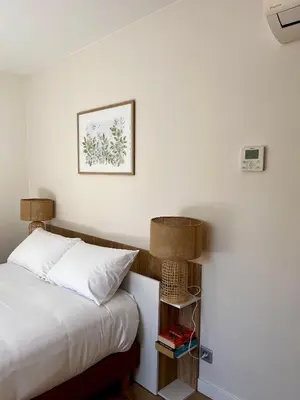 a bedroom with a bed with a night stand next to it at Appartement Jasmin 2 pièces central à Cagnes-sur-Mer in Cagnes-sur-Mer