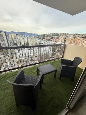 a balcony with two chairs and a table and a view at Deux pièces moderne avec balcon & Vue dégagée in Nice