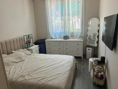 a bedroom with a bed and a dresser and a mirror at Elegant apartment in Nice with a private garden in Nice