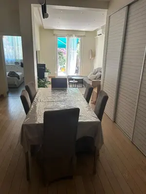 a dining table and chairs in a living room at Elegant apartment in Nice with a private garden in Nice