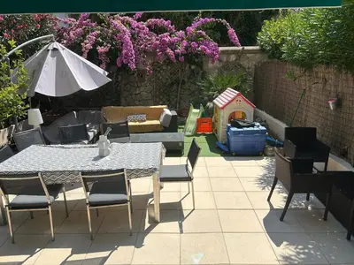 a patio with a table and chairs and an umbrella at Elegant apartment in Nice with a private garden in Nice