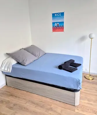 a bed in a room with a blue mattress at Royal Luxembourg Nice Prom' in Nice