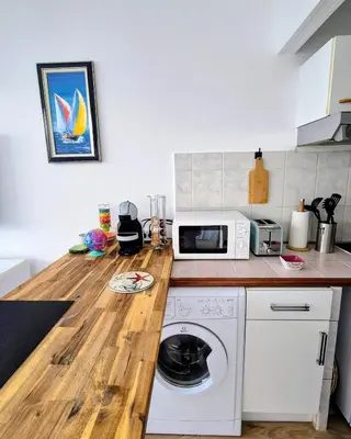 a kitchen with a counter top with a washing machine at Royal Luxembourg Nice Prom' in Nice
