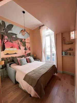 a bedroom with a large bed and a large window at Chambre arty & colorée en plein cœur de Nice in Nice