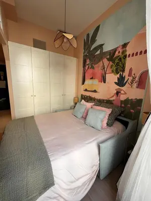 a bedroom with a large bed with pink and blue pillows at Chambre arty & colorée en plein cœur de Nice in Nice