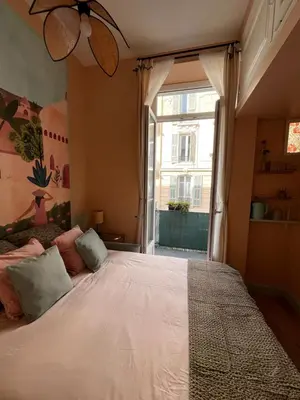 a bedroom with a large bed with a window at Chambre arty & colorée en plein cœur de Nice in Nice