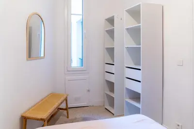 a bedroom with a white book shelf and a bed at Appartement en plein centre-ville in Nice
