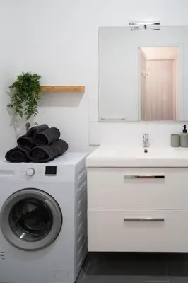 a white kitchen with a washing machine and a sink at Appartement en plein centre-ville in Nice