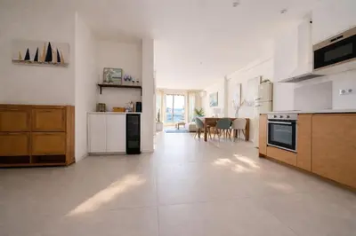 a large kitchen with white appliances and a dining room at Luxury Beachfront 2BR Promenade des Anglais in Nice