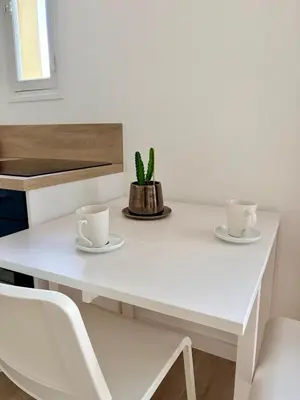 a white table with two cups and a cactus on it at Studio avec balcon - Centre-ville & plage à 2 min in Nice