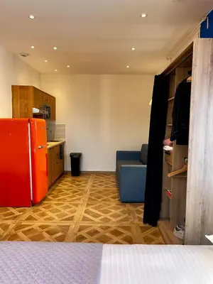 a kitchen with a red refrigerator and a blue couch at Oiseau du paradis studio central pour 4 personnes in Cagnes-sur-Mer