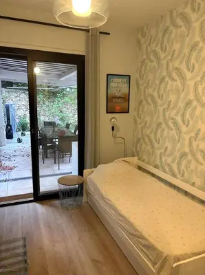 a bedroom with a bed and a table and a patio at NiceVueEnsoleille in Nice