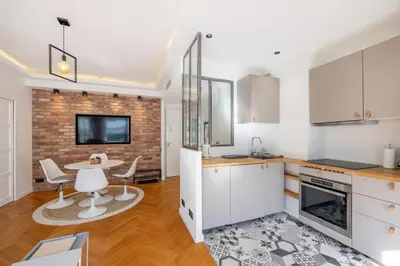 a kitchen with white cabinets and a table and chairs at Super flat in Carré d'Or - 1 minute from the sea in Nice