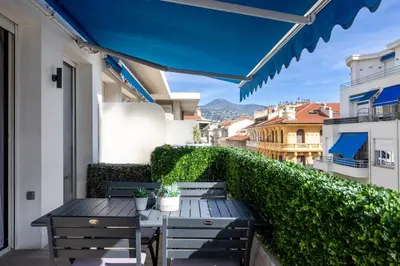 a patio with tables and chairs on a balcony at Super flat in Carré d'Or - 1 minute from the sea in Nice