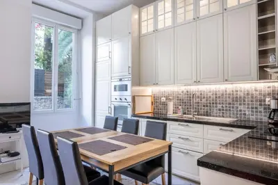 a kitchen with a wooden table and chairs at The Apartment with the Garden Studio in Nice