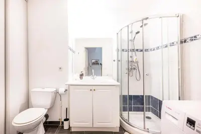 a white bathroom with a toilet and a shower at The Apartment with the Garden Studio in Nice