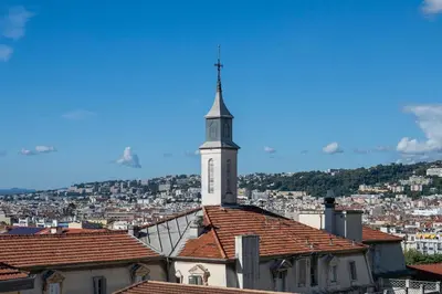 a church with a steeple on top of a building at Azur Balcony Apartment Classic Charm with View in Nice