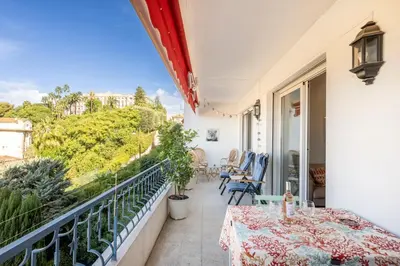 a balcony with a table and chairs and a view at Azur Balcony Apartment Classic Charm with View in Nice