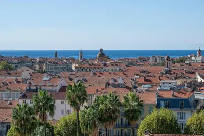 a view of a city with palm trees and the ocean at Azur Balcony Apartment Classic Charm with View in Nice