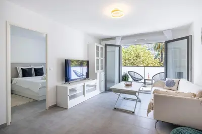 a living room with a couch and a bed and a tv at Appartement du Port with park view in Nice