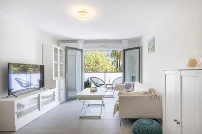 a living room with a couch and a tv at Appartement du Port with park view in Nice