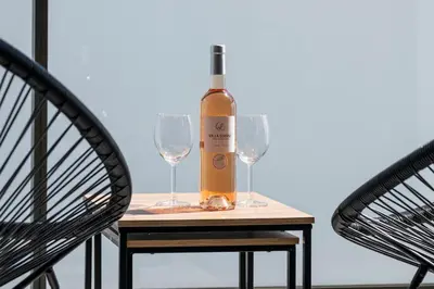 a bottle of wine and two glasses on a table at Appartement du Port with park view in Nice