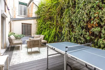 a ping pong table on a patio with a wall at Chic 3BR Oasis Near the Sea AC 2 Terraces in Nice