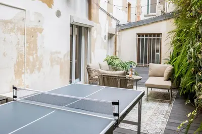 a ping pong table sitting on a balcony with at Chic 3BR Oasis Near the Sea AC 2 Terraces in Nice
