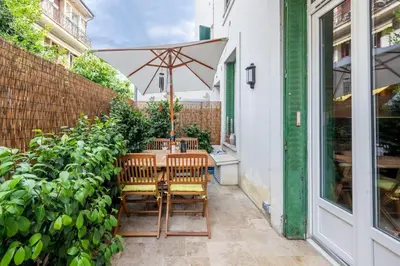 a table with an umbrella on a patio at Chic 3BR Oasis Near the Sea AC 2 Terraces in Nice