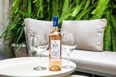 a bottle of wine sitting on a table with two wine glasses at Chic 3BR Oasis Near the Sea AC 2 Terraces in Nice