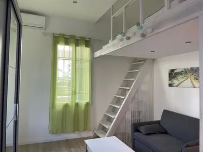 a living room with a loft bed and a couch at Beautiful studio with terrace - Nice Liberation in Nice
