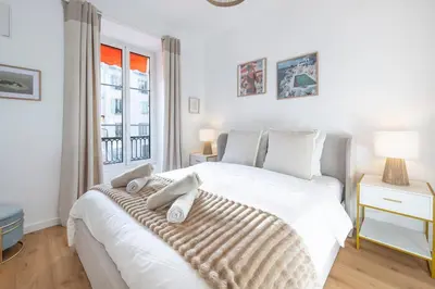 a bedroom with a large white bed with towels on it at Appartement Assalit Two bedrooms in Nice in Nice