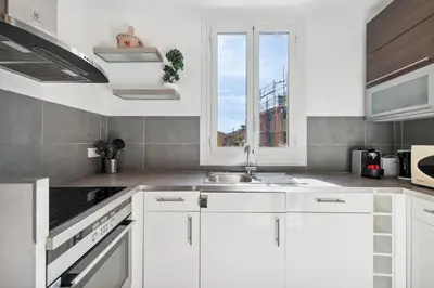a white kitchen with a sink and a window at L'Essentiel Confort - Solaire, Plage, Vieux Nice - by Studio Y in Nice