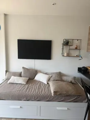 a bedroom with a bed with a flat screen tv on the wall at Air-conditioned studio comfort & cozy in Saint-Laurent-du-Var