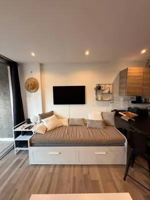 a room with a bed with a flat screen tv on the wall at Air-conditioned studio comfort & cozy in Saint-Laurent-du-Var