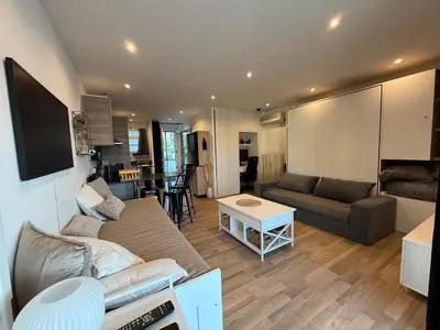 a living room with a couch and a table at Air-conditioned studio comfort & cozy in Saint-Laurent-du-Var