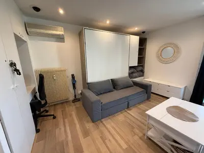 a living room with a couch and a table at Air-conditioned studio comfort & cozy in Saint-Laurent-du-Var