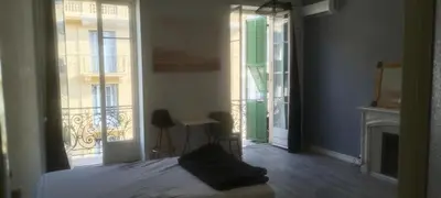 a bedroom with a bed and a balcony with a fireplace at très grande chambre climatisée plein centre Nice avec balcon in Nice