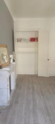 an empty room with a door and a room with wood floors at très grande chambre climatisée plein centre Nice avec balcon in Nice